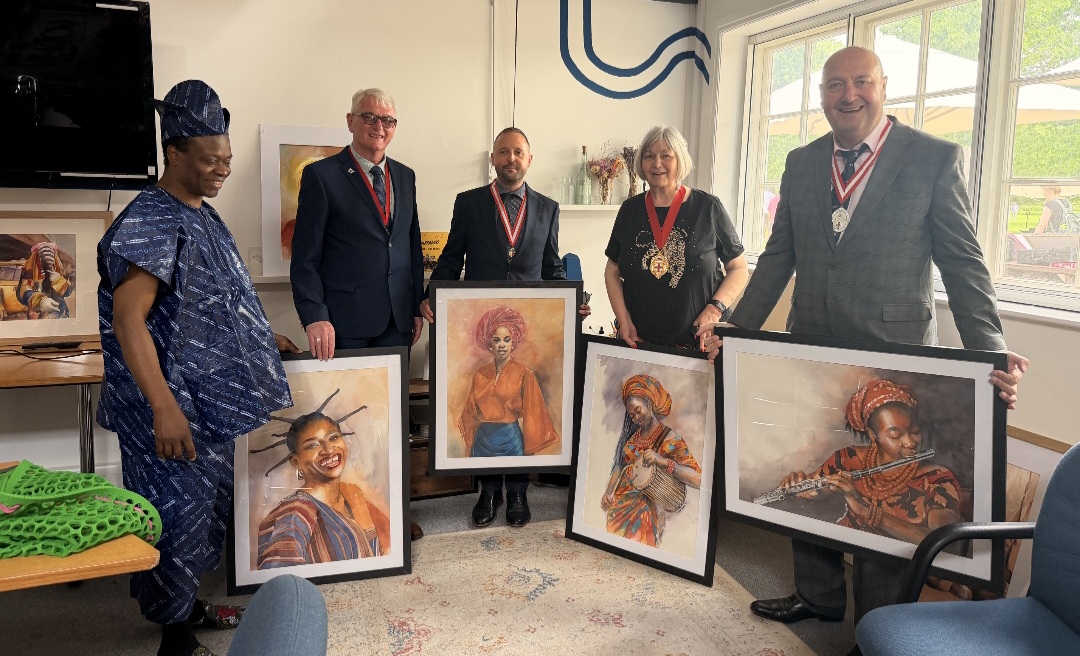 Nduka Omeife with members of the Civic Party displaying his framed paintings at Africa Day 2026